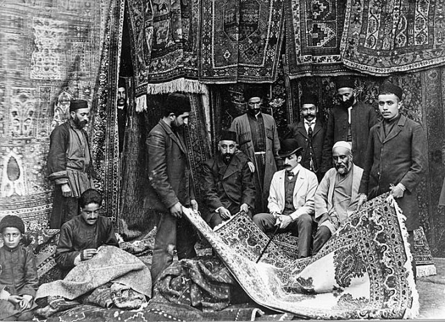 A Russian customer buying carpets from a Persian merchant in the Bazaar