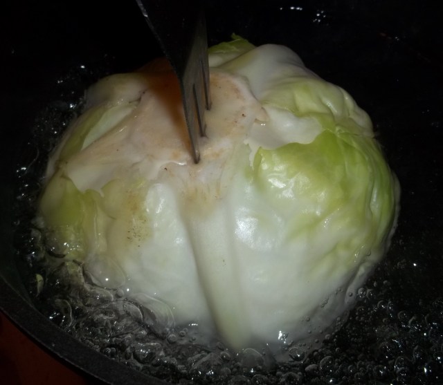 holding-the-cabbage-in-boiling-water-for-nuts in cabbage leaves-recipe