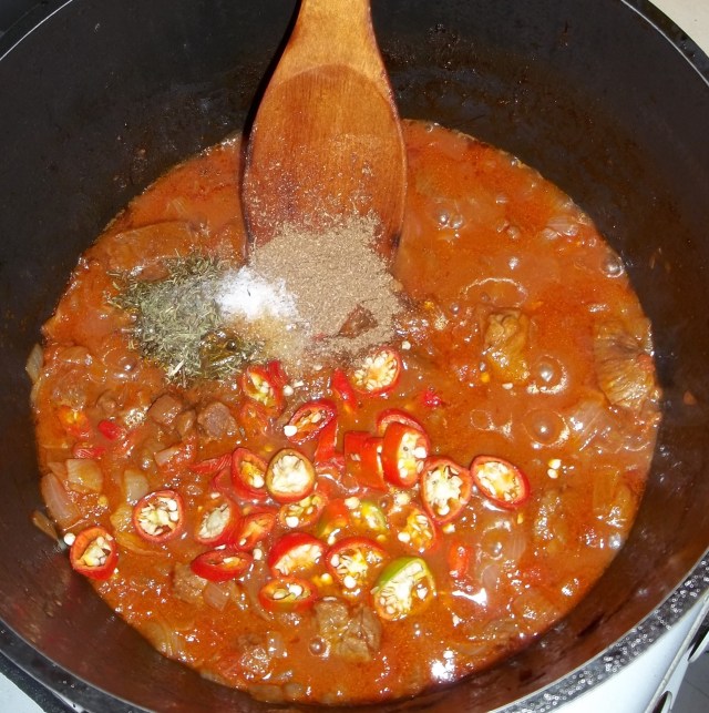 Adding Spices and Peppers to Chashushuli with Summer Savory