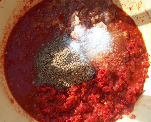 adding-spices-for-ajika-with-tomatoes-recipe