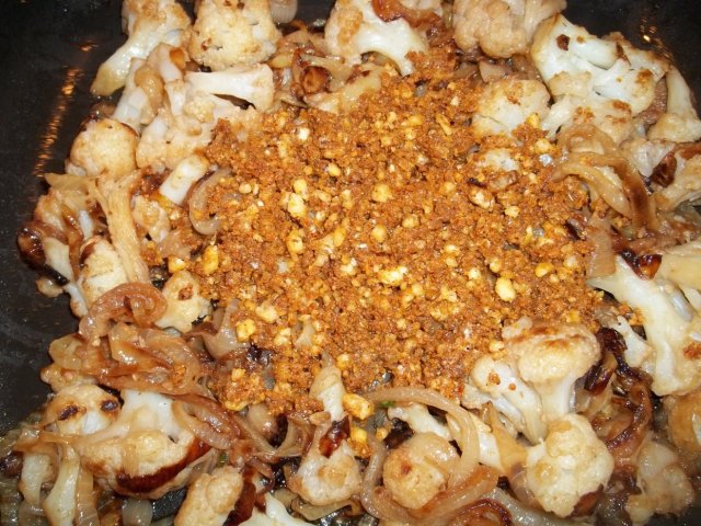 Adding Crushed Ingredients to Fried Cauliflower and Onions