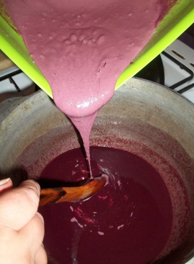 Pouring the flour and cornmeal mixture into a pot of badagi