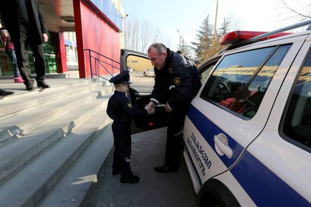 The two boys get to sit in a police patrol car