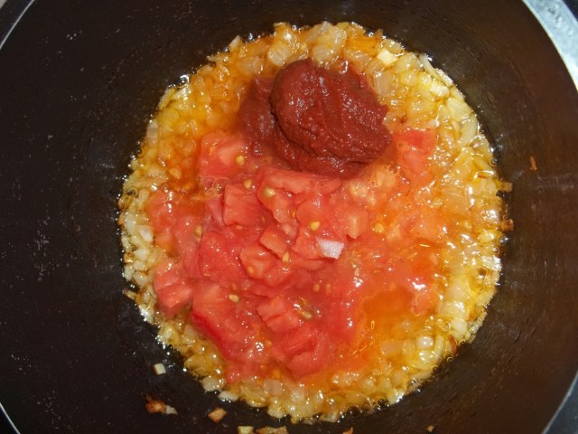 Adding tomato puree and tomatoes to fried onions - Copy