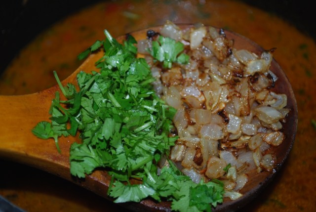 Adding Coriander and fried onions to boiled lobio