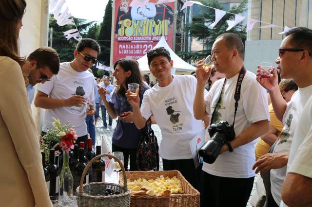 Tourists tasting wine at an event to mark Georgian Wine Day