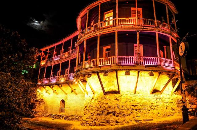 Illuminated balcony of a traditional building in Tbilisi